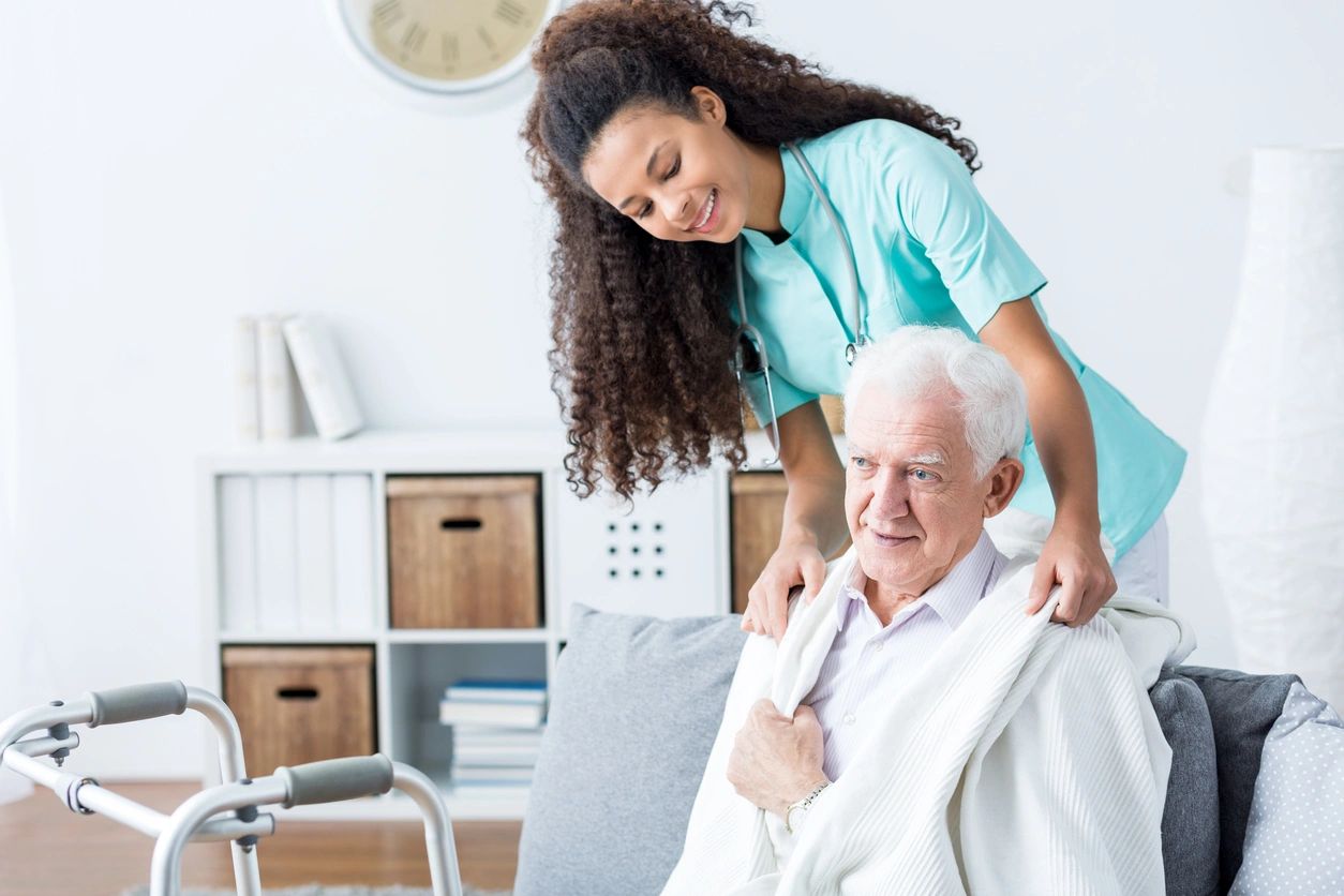 Caregiver assisting an elderly man at home
